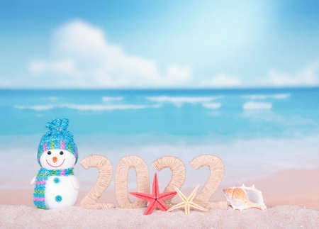 Merry Christmas. New year 2022 sign with snowman on beach backgroundの写真素材