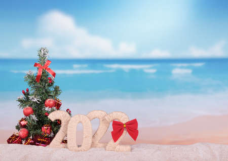 New Year 2022 sign with a Christmas tree on a beach background. Blank space for inscriptionの写真素材