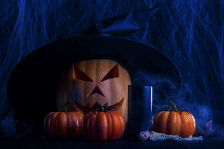 Spooky pumpkin for Halloween. Black candle, ominous smokeの写真素材