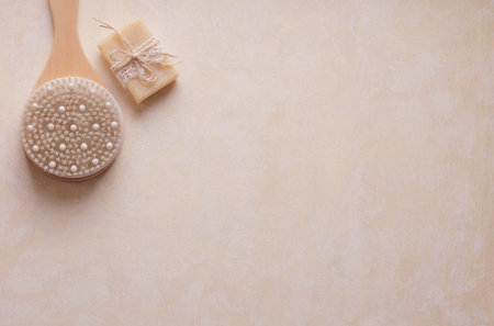 Full body dry massage brush and handmade soap from above on beige background with empty space for writingの写真素材