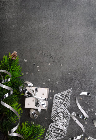 Happy New Year. Top view. Gifts with silver ribbon, confetti stars and fir branch on gray backgroundの写真素材