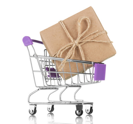 Purchase of holiday gifts. Shopping basket with gift box isolated on white backgroundの写真素材