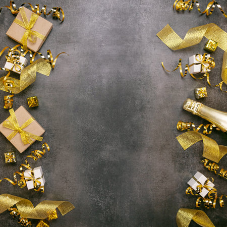 New Year card. Gifts and golden ribbons, champagne and christmas tinsel on gray backgroundの写真素材