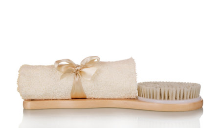 Spa set. Beige towel and soft massage body brush isolated on white backgroundの写真素材