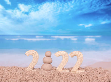New year 2022 on the beach. Sand snowman instead of 0 on the background of the seaの写真素材