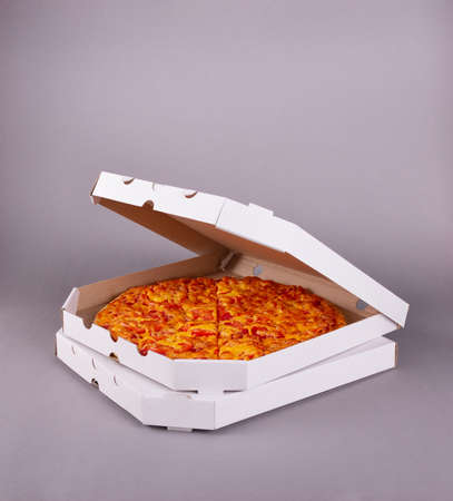 Two fragrant tasty pizzas in a box on a gray backgroundの写真素材