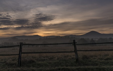 Sunrise under Milesovka hill in winter morningの写真素材