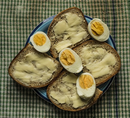 Egg with bread and butter on dirty wood tableの写真素材