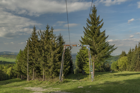 Ski slope with ski lift on Jedlova hill in spring eveningの写真素材
