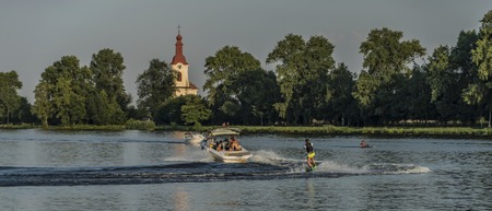 Boat on river Labe with orange sunset near Velke Zernoseky village