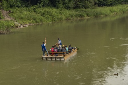 Wooden boats with passengers on Dunajec river in cold summer dayの写真素材
