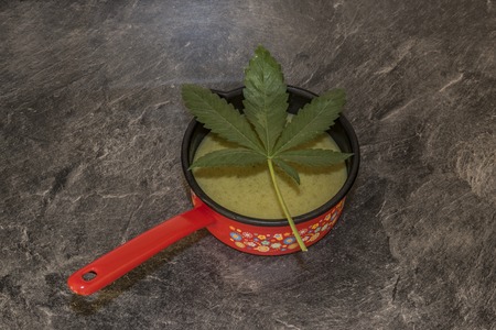 Cooking of marijuana green butter in hot water in kitchenの写真素材