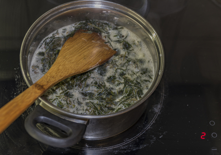 Cooking of marijuana green butter in hot water in kitchenの写真素材