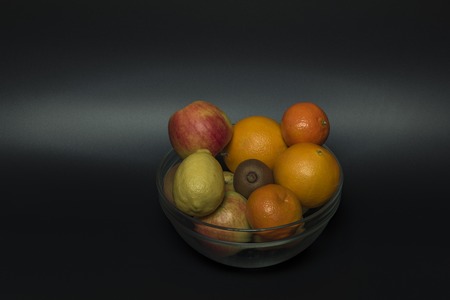 Orange mandarin kiwi apple with black background isolated
