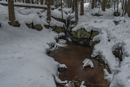 Miluscin waterfall in cold winter with white ice and snowの写真素材