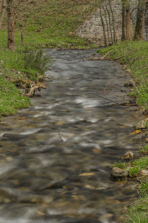 Branna river in spring cloudy evening with fresh green grass near Ostruzna village