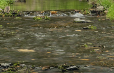 Spring small river Olesnice near Zlate Hory town with color stone