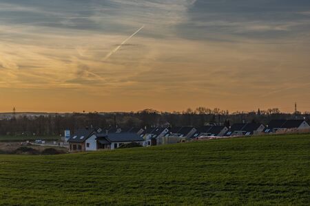 Color fields and blue sky in sunset time near spring Ceske Budejovice city with new housesの写真素材
