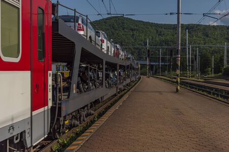 Night train with sleeping coaches and car and motorcycle coaches in Kysak station in summer hot morningの写真素材