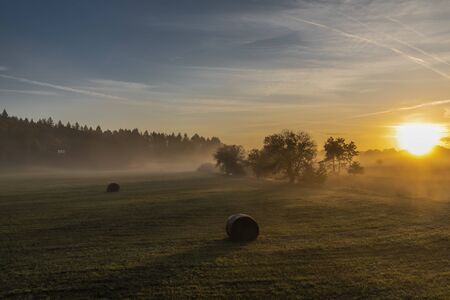 Color sunrise with fog on meadows near Pisek town in south Bohemiaの写真素材