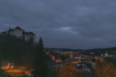 View over Vimperk town in winter dark cold evening in centre of national park Sumava with castleの写真素材