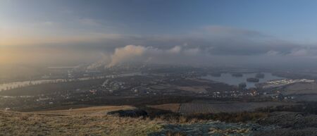 Sunrise time on Radobyl hill over valley of river Labe and Lovosice town in winter morning