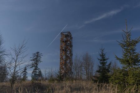 Pekelsky hill with observation tower and flying airplane and blue sky in winter sunny dayの写真素材