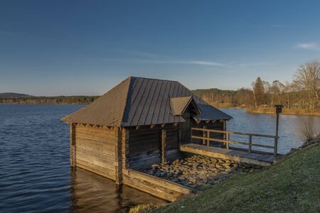 Olsina pond near Hodnov village in spring sunny evening with wooden cottageの写真素材
