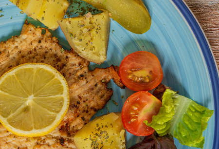 Vegetable fruit yoghurt apricot courgette chicken on blue plate with wooden color table