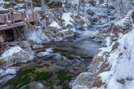 Wooden mill house near Ramsaubach creek in frosty cold snowy morning in Austriaの写真素材