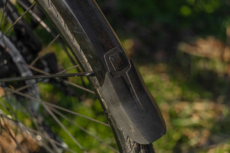 Black and gray electric bicycle in sunrise morning time on frosty field with yellow sun