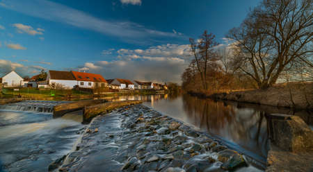 Big weir on Vltava river in Roznov part of Budweis city in winter spring sunset color evening