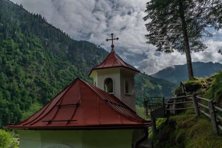Wolfaukapelle chapel in sunny cloudy morning in Austria color mountainsの写真素材