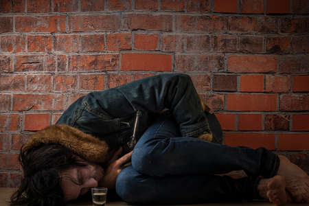 Black hair man with vodka bottle near old red brick wallの写真素材