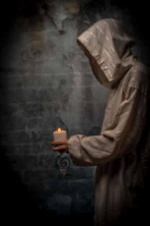 Tall man with long priest dress with stone old wallの写真素材