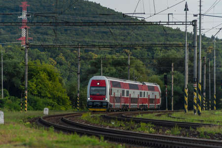 Passenger train with electric red unit in summer cloudy eveningの写真素材