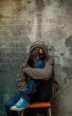 Male with gray sweater with hood and textile bag and blue jeans pantsの写真素材