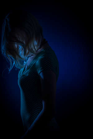 Blond hair young woman with dark green fresh background