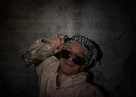 Arabian man near old stone wall with black white bandanna on headの写真素材