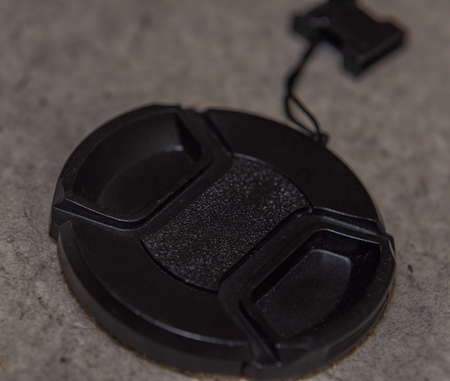 Black accesories for camera with lens on hairy dirty bad background