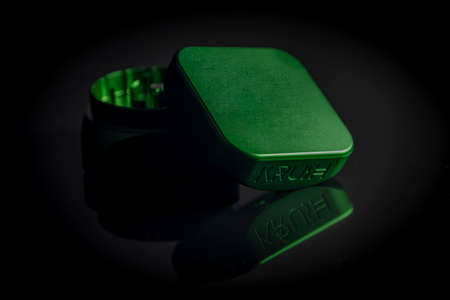 Green metal new grinder with bounce on black sleek tableの写真素材