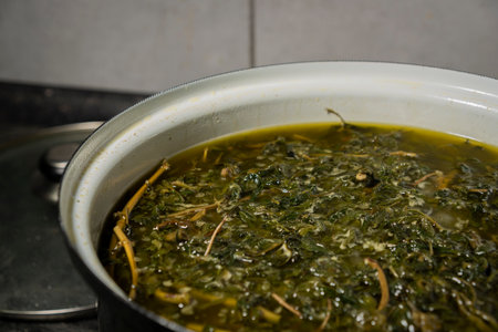Cooking of yellow and green marijuana medicinal butter in hot water in kitchen