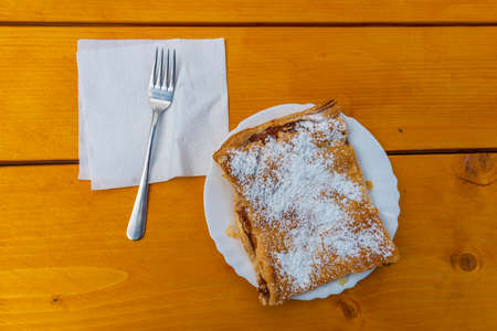 Strudel with apples and cinnamon and sugar on wooden new table in Velika Planina summer fresh nature