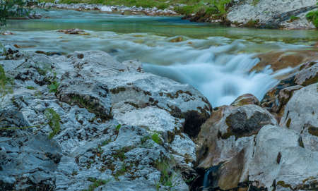 Light blue water in Soca river in summer hot evening in Slovenia mountainsの写真素材