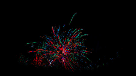 Color fireworks on black sky in New Year midnight