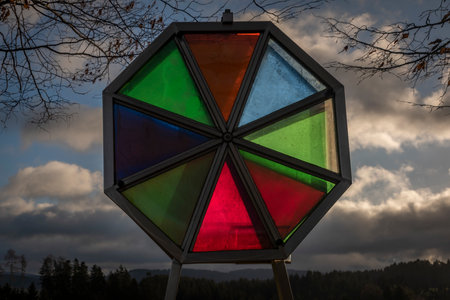 Color glass oval near green meadow and forest in Austria winter countryside
