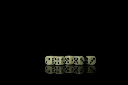 Yellow game cubes on shiny black table with dark reflection