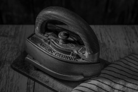 Old metal iron on old wooden blue table with dirty chopping boardの写真素材