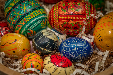 Color easter eggs in light wooden bowl on blue old wooden dirty table