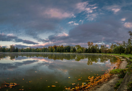 Stromovka park with trees forest and pond Bagr in autumn color morningの写真素材